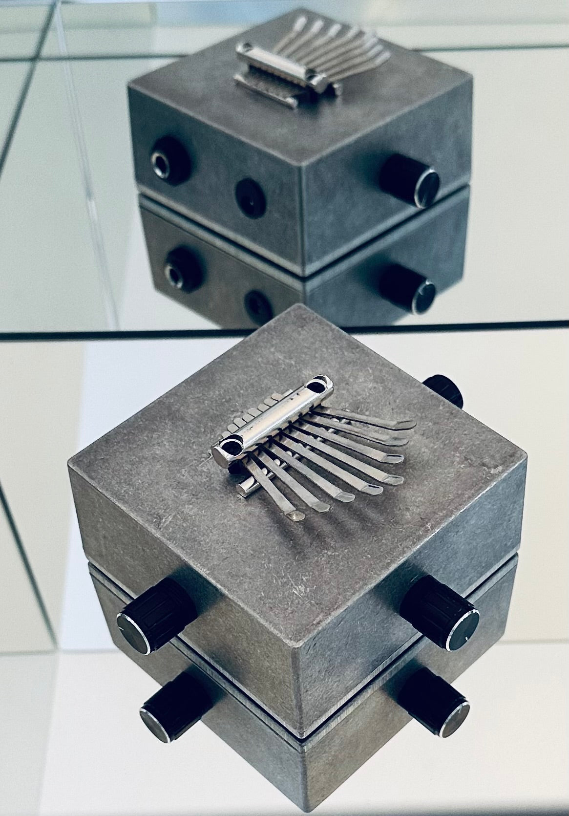 Metallic Kalimba with decorative elements on a reflective surface