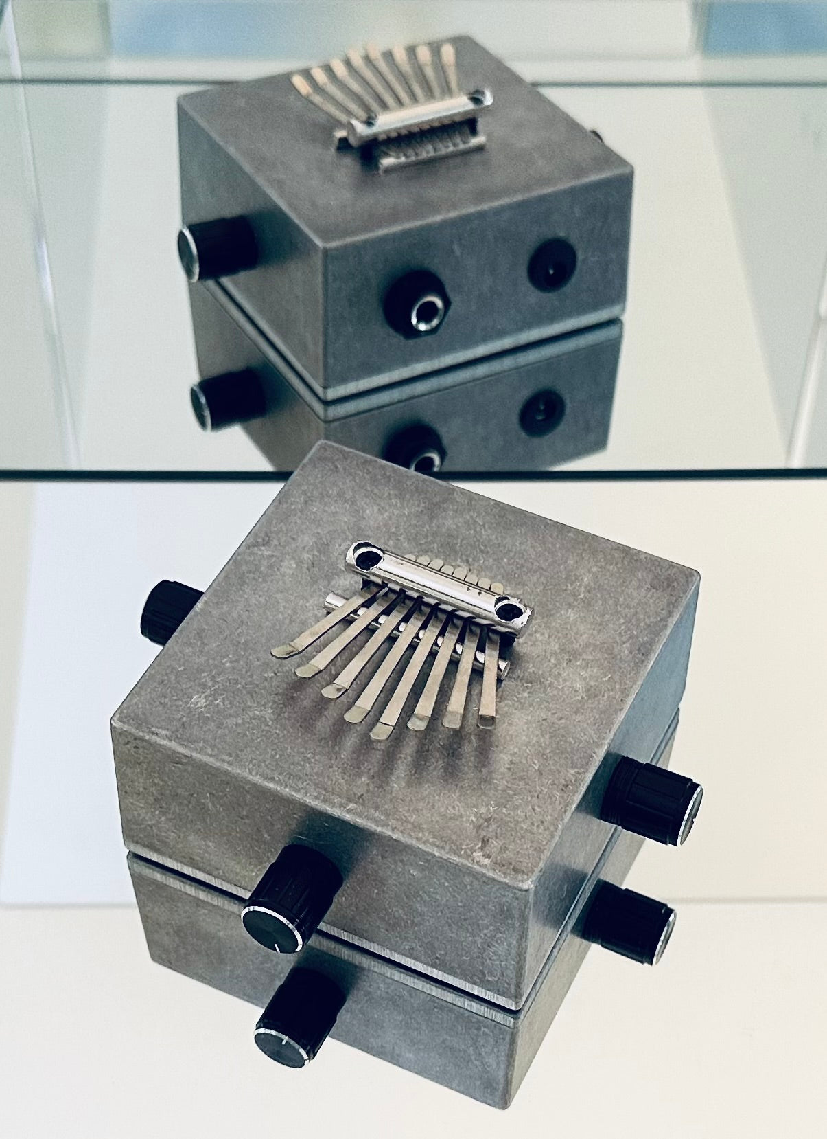 Side image metallic kalimba instruments on a reflective surface